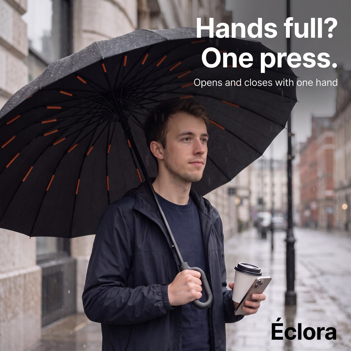 Hands full? One press: a man holding the open Éclora StormHook in one hand, a coffee and a phone in the other